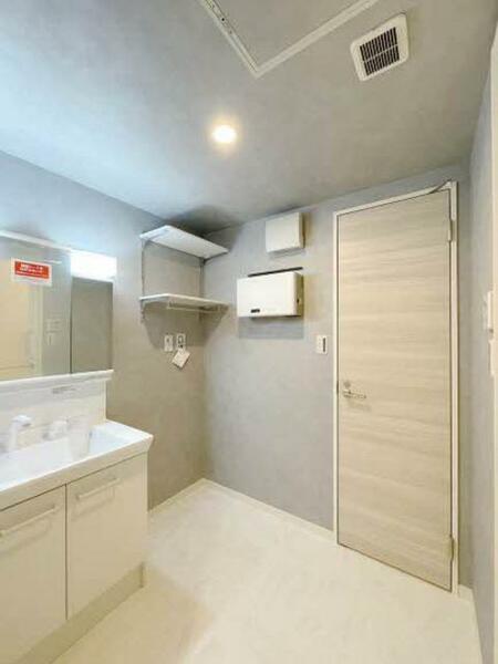 画像11:【洗面所】シックなアッシュグレーの壁紙を施した洗面所。洗濯機スペース上部には、洗剤などを置くのに便利
