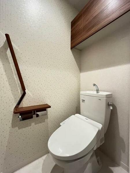 画像15:【トイレ】素材感の違うホワイトカラーで、清潔感のある印象のトイレ。上部吊戸棚、手摺、小物置きに使える