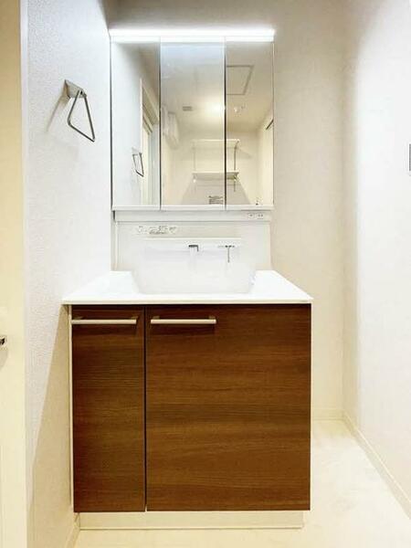 画像10:【洗面台】三面鏡タイプの洗面台。水栓には小物を置けるスペースがあるので、コンタクトを置いたり、化粧品