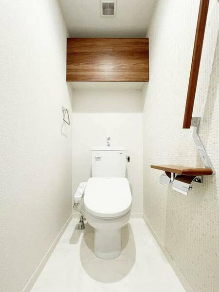 画像11:【トイレ】清潔感あふれるトイレ。上部吊戸棚、手摺、小物置きに使えるペーパーフォルダー天板があり、機能