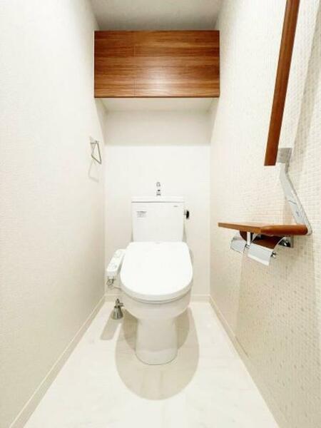 画像11:【トイレ】素材の違うホワイトベースの色調で、清潔感を感じるトイレ。上部吊戸棚、手摺、小物置きに使える