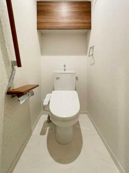 画像10:【トイレ】タイル調のアクセント壁がおしゃれなトイレ。上部吊戸棚、手摺、小物置きに使えるペーパーフォル