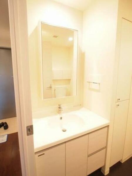 画像13:洗面所は白で統一。鏡の裏は収納になっています。