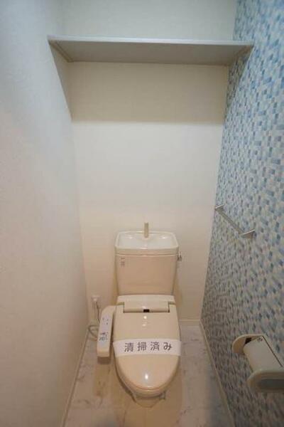 画像16:洗浄機能付き便座のお手洗いです。アクセントクロスを貼っています。上部には収納棚があります。