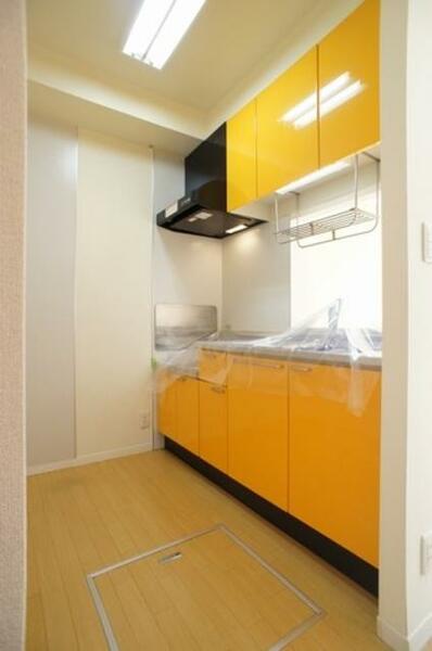 画像11:鮮やかなオレンジのパネルがポップな印象で明るい雰囲気のキッチン♪水切り棚や上下に収納スペースを設けて