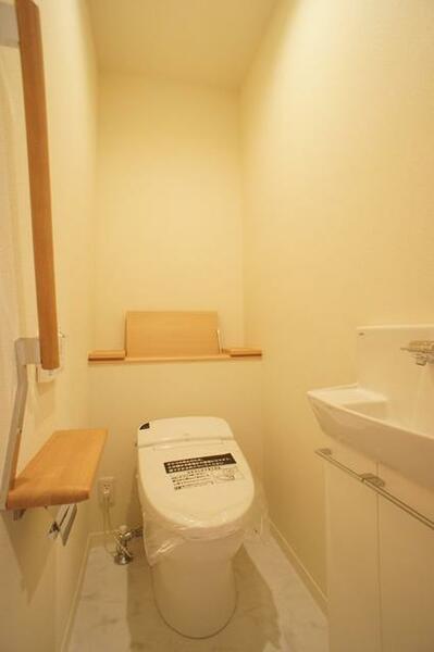 画像10:タンクレスのシャワートイレはリモコン操作タイプです。背面には目立たない収納棚、正面には手洗いも付いて