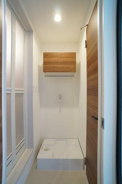 画像14:洗濯機置き場の上部にはランドリー用品の収納ができる扉付きの棚を設置しています。