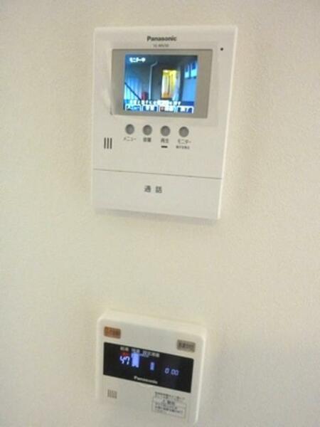 画像10:Panasonic製のカラー録画機能付きインターホン（上）とPanasonic製の電気温水器用リモコン（下）をキッチン