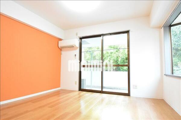 画像3:2面採光でオレンジのアクセントクロスが映えるお部屋。