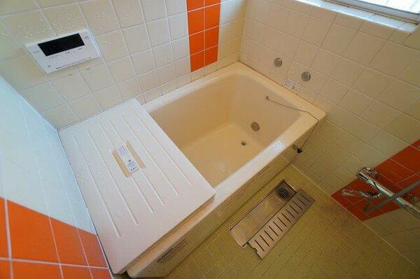 オレンジのタイルがアクセントになっている浴室です