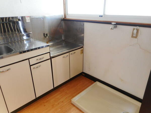 画像4:明るいキッチンです。吊戸棚と窓・洗濯機パンがあります。