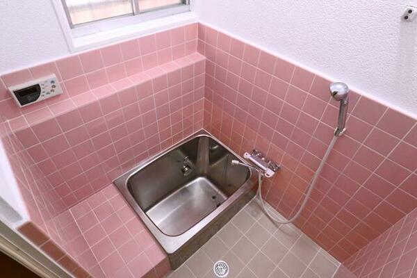 白い壁とピンクのタイルがかわいいお風呂