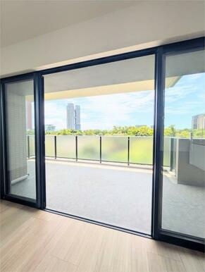 明るい陽光が差し込むリビング。バルコニーからは緑豊かな景色が広がり、開放感あふれる空間です。
