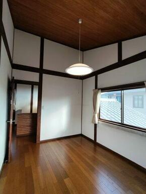 2階約6帖の洋室。真っ白の壁と濃い木目調のバランスが綺麗な内装です