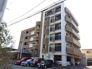 落ち着いた色合いの外観が魅力のマンション。屋根付き駐車場を完備し、雨の日も安心です。日当たりの良いバ