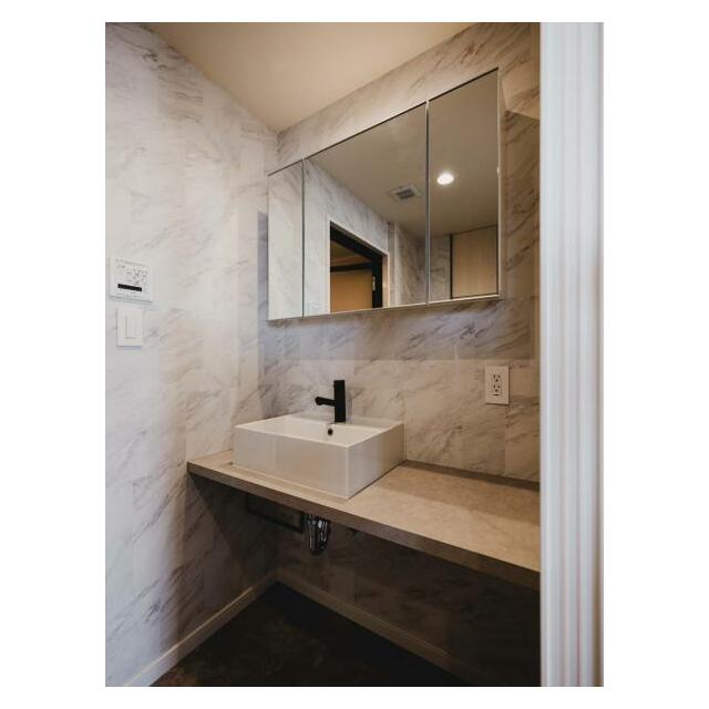 大理石調の洗面スペースは高級感があります。ミラーボックスの中にサニタリーグッズを収納することも。