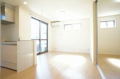 【ＬＤＫ】キッチン側から見たＬＤＫ。２方向に窓がある角部屋です。備え付けのエアコン、ＬＥＤシーリン…