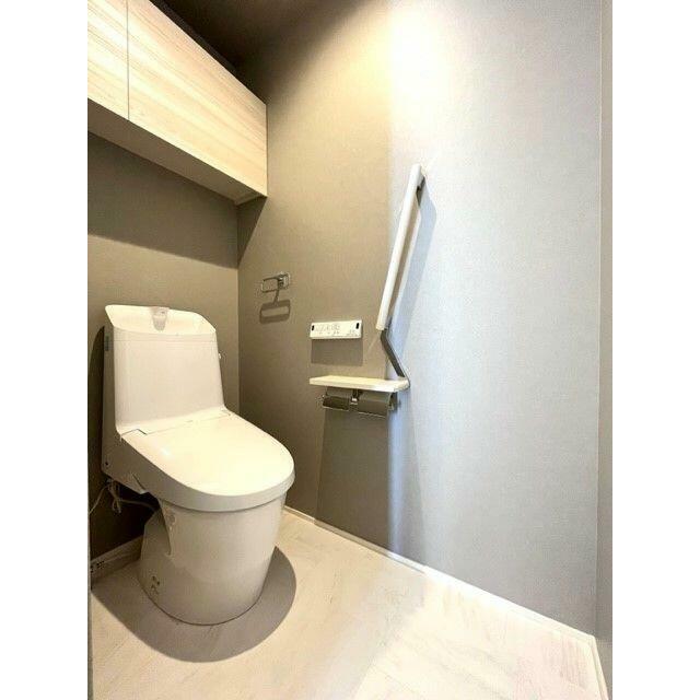 トイレ　洗浄機能付き暖房便座を設置、上部には吊戸棚がございます