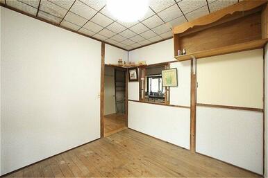 キッチンの後ろにフローリングの部屋があります