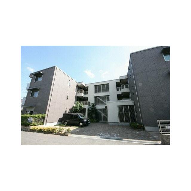 エントランス側より撮影。白とダークブラウンの建物です。