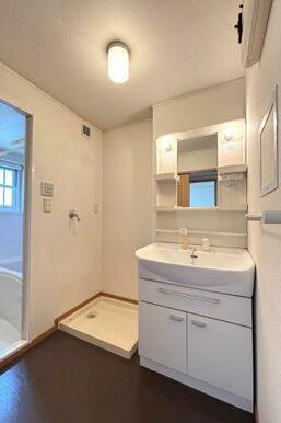 鏡の両脇に収納スペースを確保した洗髪洗面化粧台は、水栓がリフトアップするので洗髪もラクラク♪