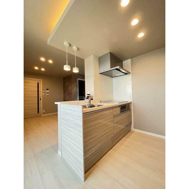 【システムキッチン】対面キッチンでペンダントライトが備え付けてあり、明るいトーンのキッチンとなって…