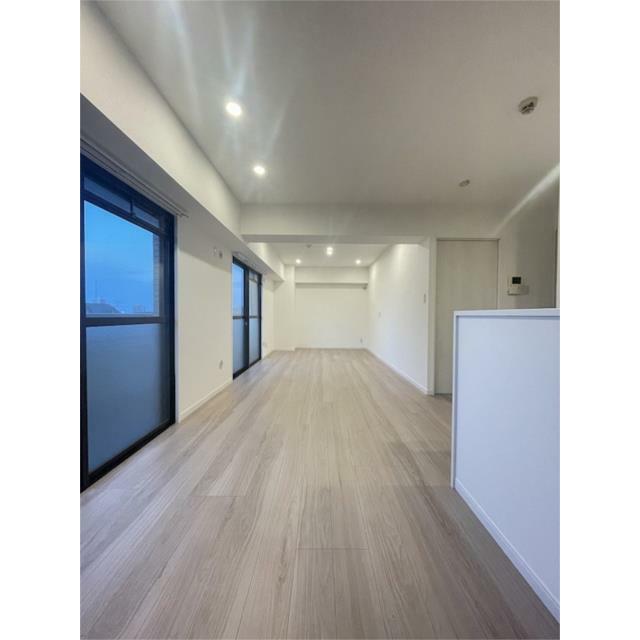 明るい木目調の床とダウンライトが印象的なリビング。窓から差し込む光が空間をさらに開放的に演出し、家族