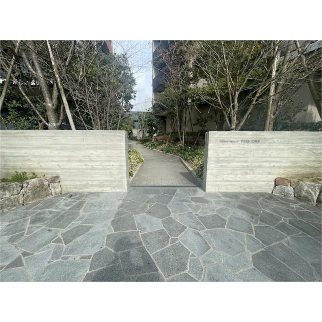 緑豊かなアプローチを抜けると、洗練された石畳とモダンな外壁が、住まいの顔を彩ります。