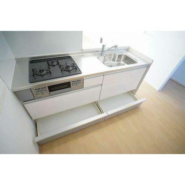 【システムキッチン】オールスライド収納タイプの対面型システムキッチン（ガス・３口・グリル付）を採用。