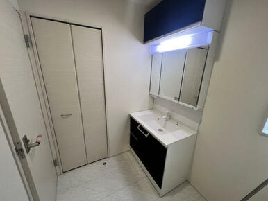 (9)号棟:吊戸のある洗面化粧台。タオルや着替えを収納できるリネン収納。
