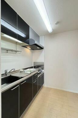 扉パネルを鏡面仕上げの黒で統一し、モダンな印象のキッチン♪上下に収納が豊富なのでキッチン周りをきれ…