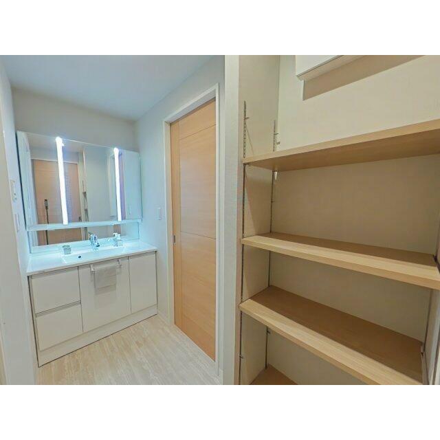 脱衣スペースは白と木目を基調とした明るく、清潔感のある空間です。