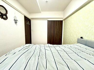 ブラウンのクローゼットが落ち着いた印象を与える寝室。シンプルで上品な内装が家具との調和を引き立てます