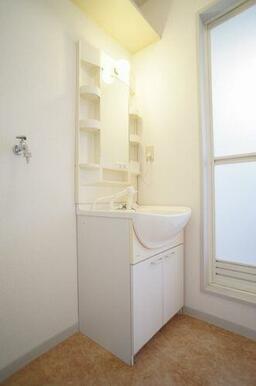 ■洗面脱衣所■忙しい朝の洗髪に大助かりの洗髪洗面化粧台と棚を配した洗面脱衣所♪