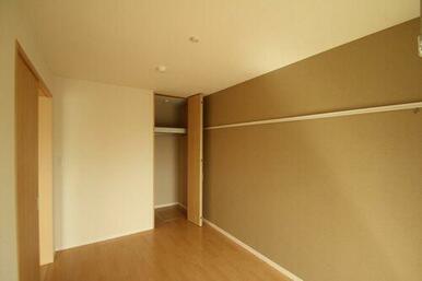 窓側から見た６．１帖の洋室です。ハンガーパイプが設置されたクローゼットがあり、スーツ等の洋服が収納…