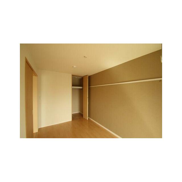 窓側から見た６．１帖の洋室です。ハンガーパイプが設置されたクローゼットがあり、スーツ等の洋服が収納…