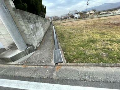 敷地と道路の間には幅の細い側溝があります。こちらの写真は西側の道路。法外道路で幅員約1.0ｍあります。