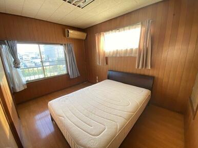 大きな窓からたっぷり自然光が入る洋室。木目調の壁が温かみを演出し、寝室や書斎としても快適にお使いいた