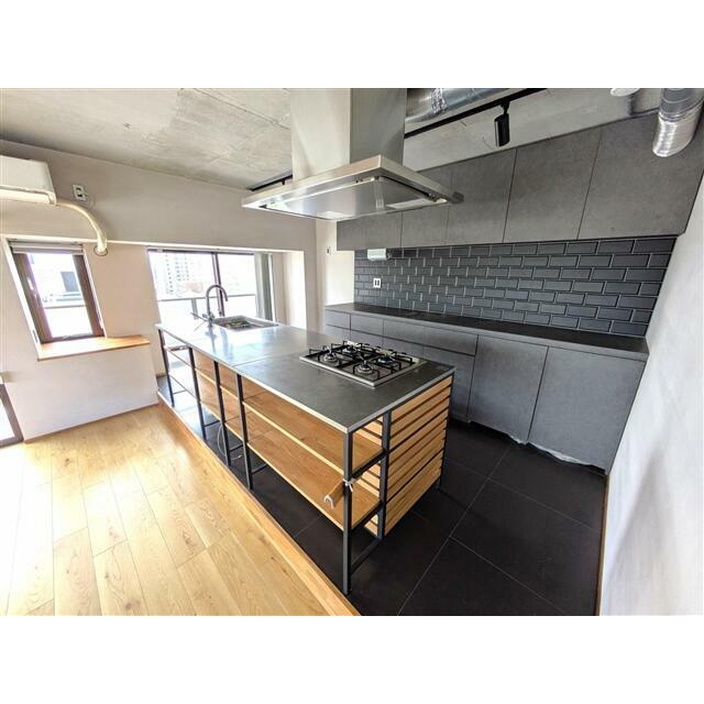 シックな印象のアイランドキッチン。コンロは4口、ここにも床暖房が付いております。