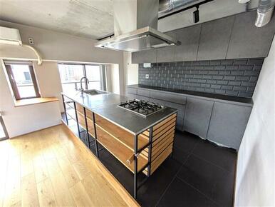 シックな印象のアイランドキッチン。コンロは4口、ここにも床暖房が付いております。