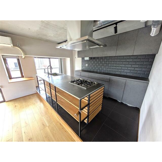 シックな印象のアイランドキッチン。コンロは4口、ここにも床暖房が付いております。