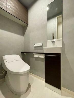 トイレ　洗浄機能付き暖房便座を設置、上部には吊戸棚がございます。