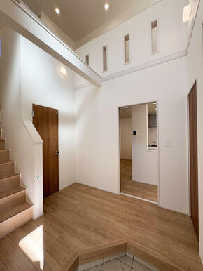 吹抜けで味わえる圧巻の開放感のある玄関。窓から光が差し込み明るい玄関を是非現地にて体感して頂ければと