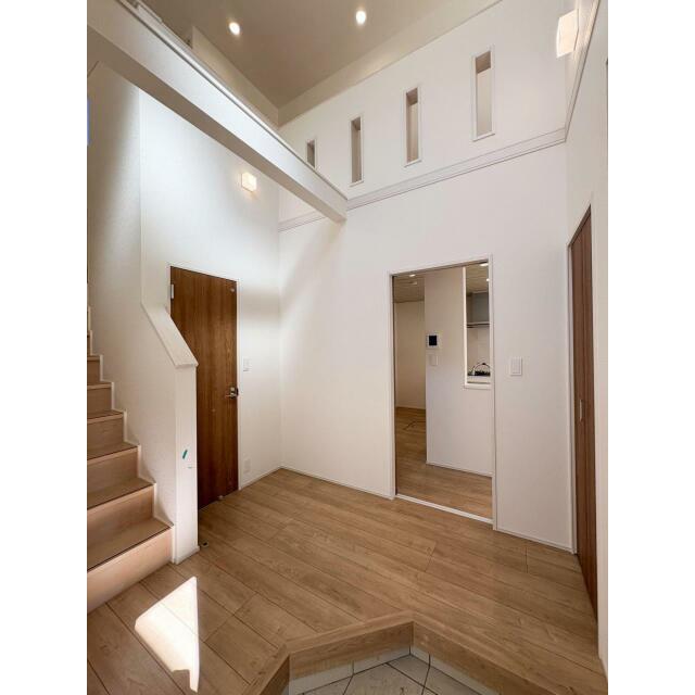 吹抜けで味わえる圧巻の開放感のある玄関。窓から光が差し込み明るい玄関を是非現地にて体感して頂ければと