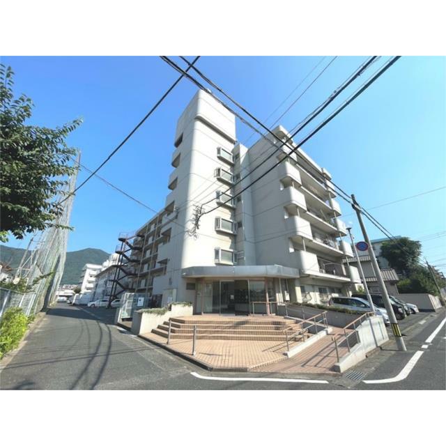 青空の下に佇む、堂々とした外観のマンションです。エントランスは落ち着いた雰囲気で、歩道に面しており、