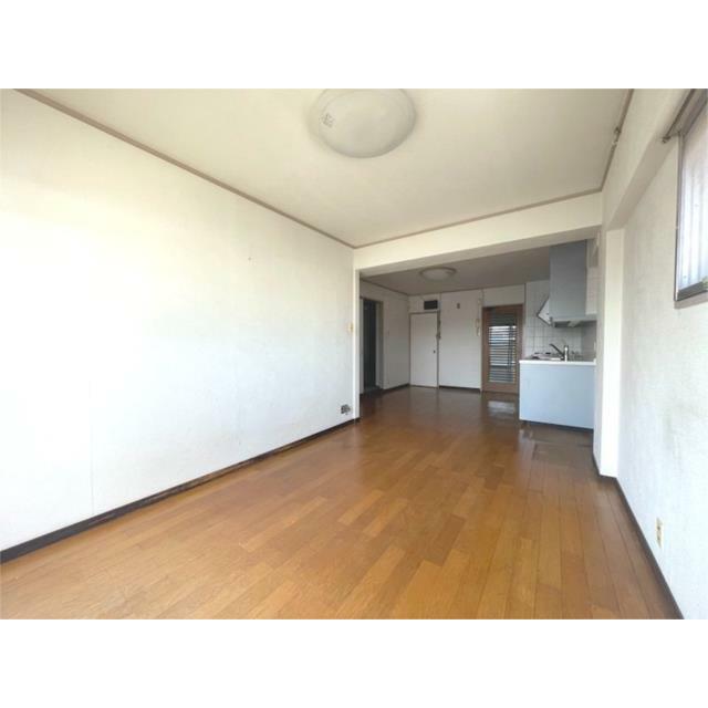 明るい日差しが差し込むリビングは、木目調のフローリングで温かみのある空間です。窓から光が入り、開放感