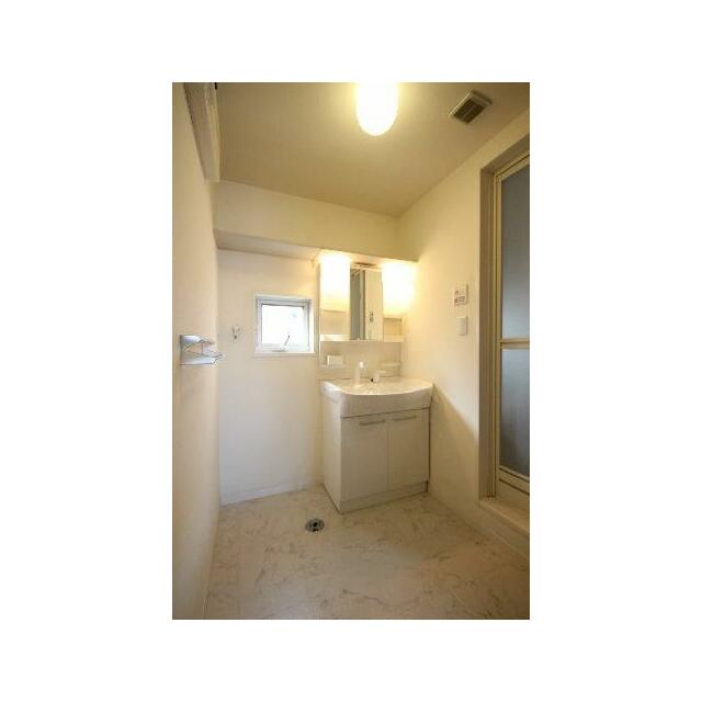 洗面スペースにも小さな小窓が付いています。化粧台上部には棚が設けられているため、備品のストック場所…