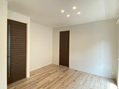 天井埋め込みのダウンライトがダーク系の室内とアクセントクロスを引き立たせ、おしゃれな雰囲気を作り出…