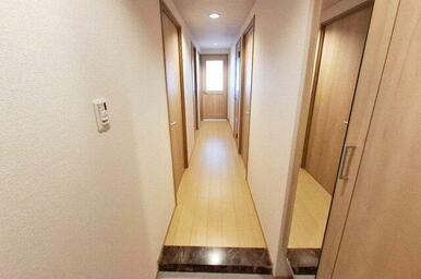 廊下：フローリング新調済み。真っ直ぐ続く廊下は無駄のない設計。生活動線がスムーズに保たれます。