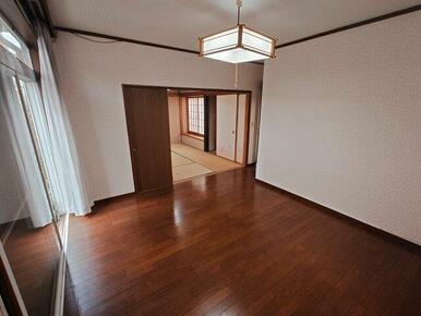 庭に面した窓の大きい居間です。（11.5帖）カーテンレールが見えないように板が通してあります。雨戸付き